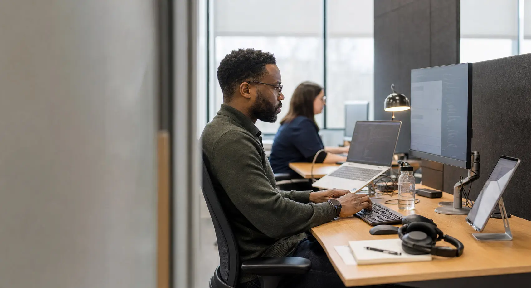 A software engineer builds and tests a business application across a workstation and tablet.